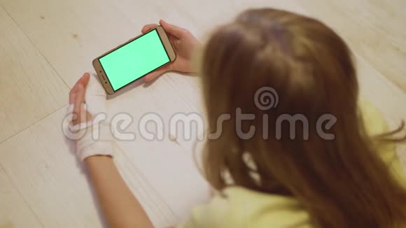 年轻的白种人金发左手骨折看着智能手机的绿色屏幕近景视频的预览图