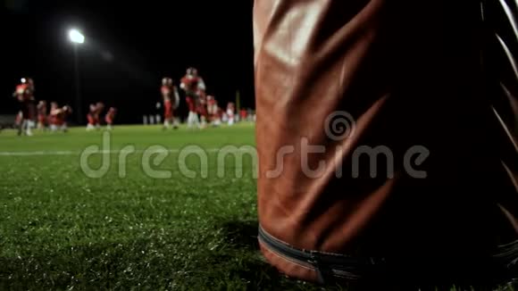 当足球运动员在夜间比赛前热身时多莉在球门柱后面视频的预览图