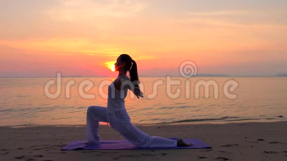 亚洲女子在日落海练习瑜伽视频的预览图