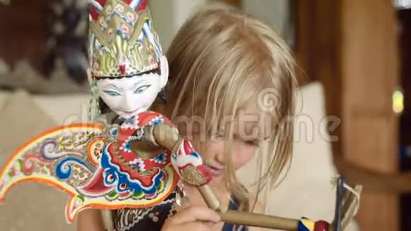小女孩在检查一个巴厘岛娃娃视频的预览图