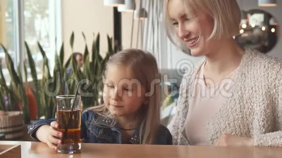 小女孩在咖啡馆里用吸管喝饮料视频的预览图