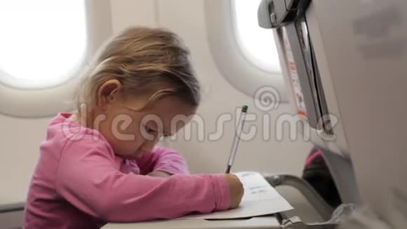 小女孩坐在飞机上看着照明器视频的预览图
