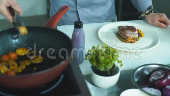 厨师把蔬菜放在一盘肉上视频的预览图