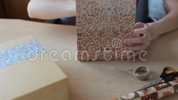女人手把礼物包在木桌上视频的预览图