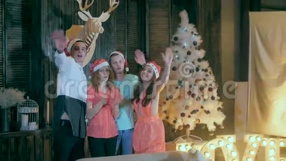 慢动作快乐的一群朋友在圣诞晚会上挥舞着手微笑着走进镜头视频的预览图