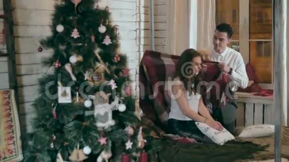 年轻人用温暖的毯子呵护他的女朋友一对相爱的情侣庆祝圣诞节视频的预览图
