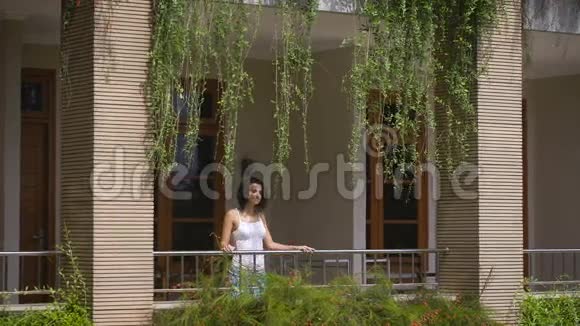 美丽的女性旅行者正走在她热带别墅的阳台上呼吸着清新的巴厘岛空气青年视频的预览图