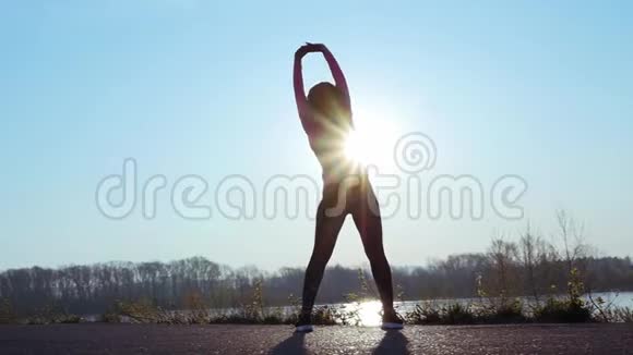 运动的女人在日出时在河岸上参加运动慢动作视频的预览图