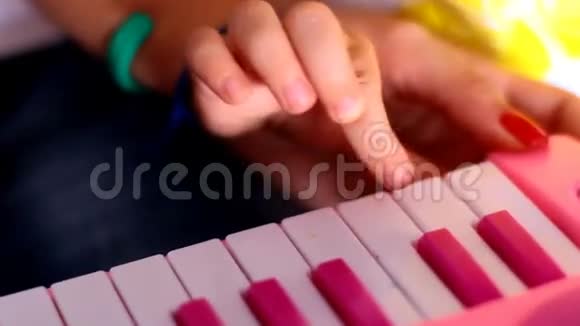 宏小指一个接一个地按下粉红色钢琴的键视频的预览图