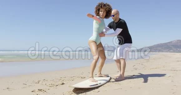 男人教女人站在冲浪上视频的预览图