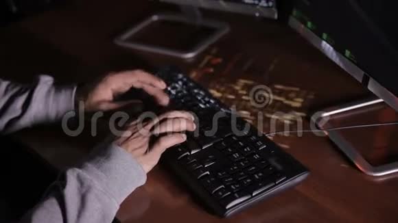 顶部视图在黑暗的房间里男人用手在键盘上打字黑客专业电脑专家视频的预览图