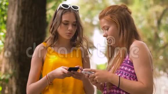 夏季公园里带智能手机的少女视频的预览图