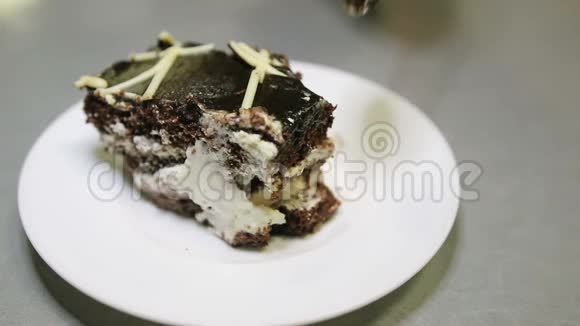 用勺子把一块巧克力蛋糕放在盘子里视频的预览图