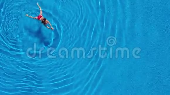 从顶部看一个穿红色泳衣的女人在游泳池里游泳视频的预览图
