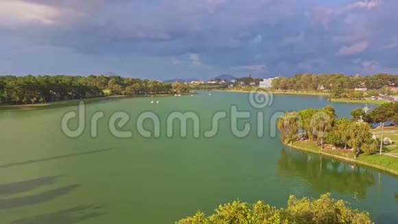 从宁静的绿色湖泊中取出一颗带有岛屿的飞行摄像头视频的预览图