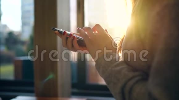 在夕阳下女性用智能手机对抗模糊的城市景观视频的预览图