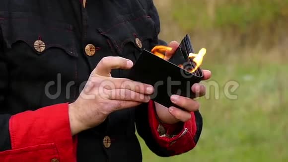 魔术师打开钱包把它点燃他在邋遢的地方打了起来视频的预览图