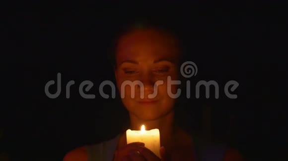 年轻的女人看着蜡烛视频的预览图