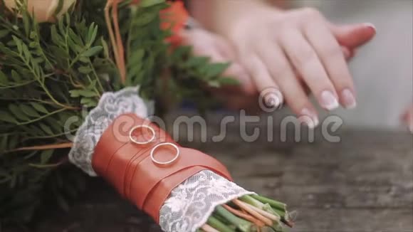 新郎新娘的特写和结婚花束上的戒指婚姻概念视频的预览图