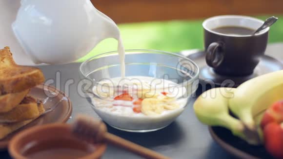 电影摄影新鲜麦片梅斯利浆果和倒牛奶在碗里视频的预览图