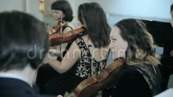 交响乐厅演奏小提琴的音乐家特写视频的预览图