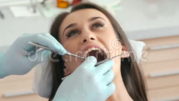 牙医检查年轻漂亮女人的牙齿视频的预览图