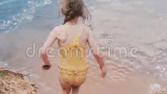 快乐而微笑的小女孩穿着泳衣跳进水里溅起水花微笑着玩得很开心视频的预览图