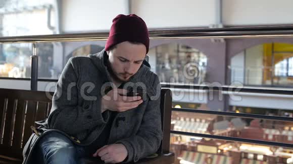 大超市里坐着智能手机的快乐男人的画像视频的预览图