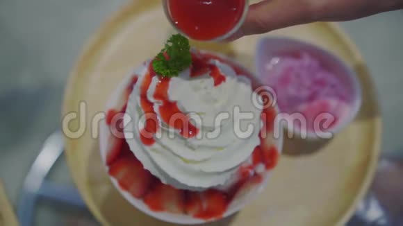 将酱汁倒入刨冰或草莓味新鲜牛奶上视频的预览图