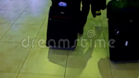 机场大理石地板上的大型黑色手提箱视频的预览图