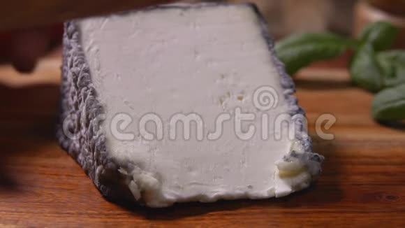 刀在木板上切一块柔软的山羊奶酪视频的预览图