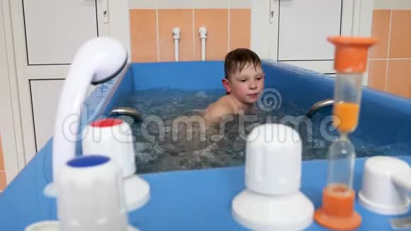 小男孩正在用泡泡洗澡按摩浴缸泡浴程序视频的预览图
