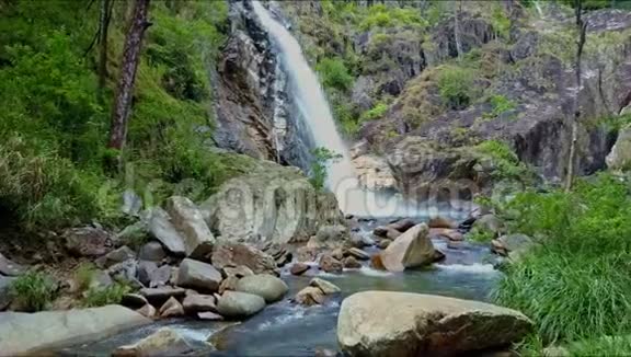 雄蜂沿着河流和湖泊接近岩石间的瀑布视频的预览图