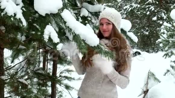 女孩在冬天的树林里散步视频的预览图