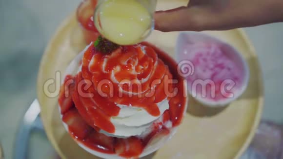 将酱汁倒入刨冰或草莓味新鲜牛奶上视频的预览图