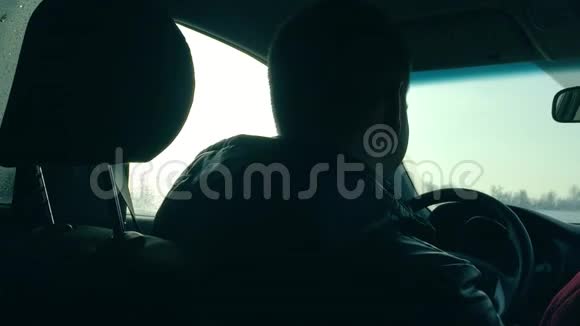 男人开着一辆冬天的汽车从车内看室外道路上的人的运动视频的预览图