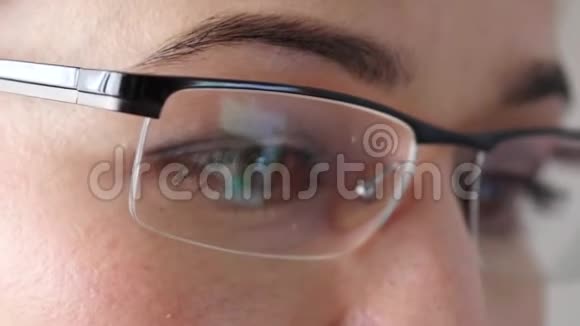 戴眼镜的棕色女人眼女人用智能手机4K视频的预览图