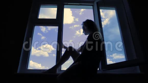 坐在窗户上的漂亮年轻女人视频的预览图