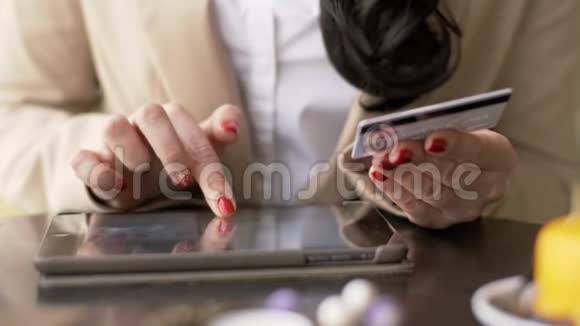 妇女在使用智能手机上网购物时会使用信用卡视频的预览图