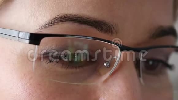 戴眼镜的棕色女人眼女人用智能手机4K视频的预览图