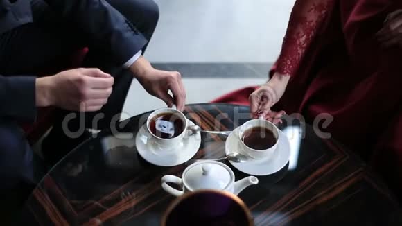 咖啡馆里情侣手的近景他们正在喝茶把杯子放在原地视频的预览图