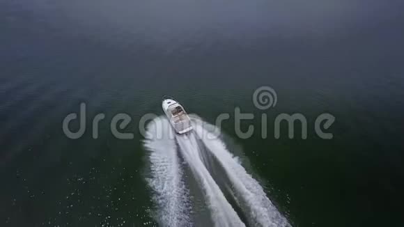 4k空中飞弹白色小型豪华摩托艇游艇在平静的河流海水飞溅中缓缓航行视频的预览图