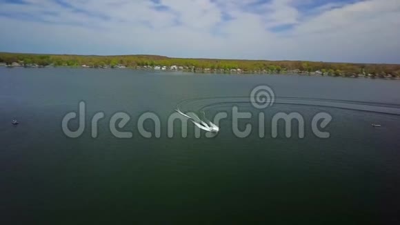 白色小型豪华摩托艇游艇在平静的河流中缓慢航行海水飞溅海浪惊人的4k空中射击视频的预览图