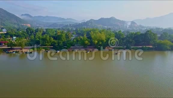 在岸边的小镇上从绿色宁静的河流中飞起视频的预览图