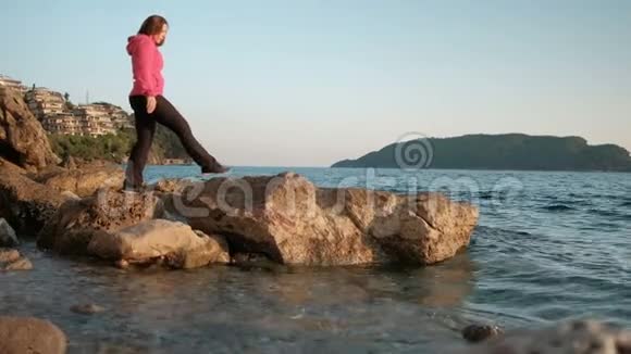 女人走在湖岸上踏着石头眺望远方视频的预览图