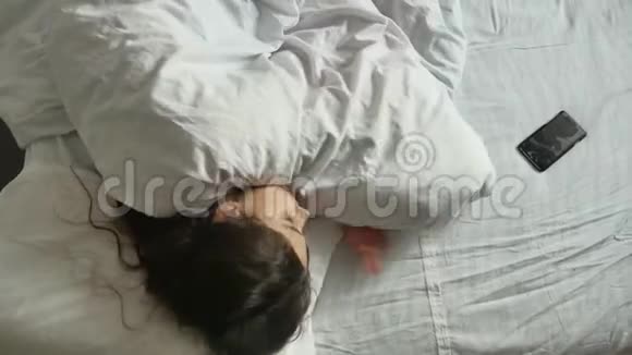 小可爱的室内女孩睡在床上睡在床上的小女孩从上面可以看到生活方式视频的预览图