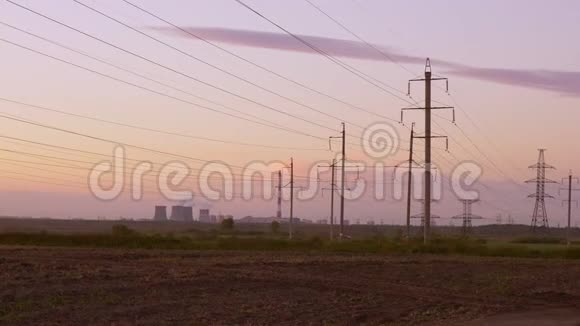 黄昏时蒸汽从电厂的冷却塔中升起电力传输线在前面视频的预览图