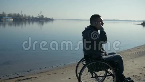 男性残疾人在手机上讲话肢体残疾人坐着视频的预览图
