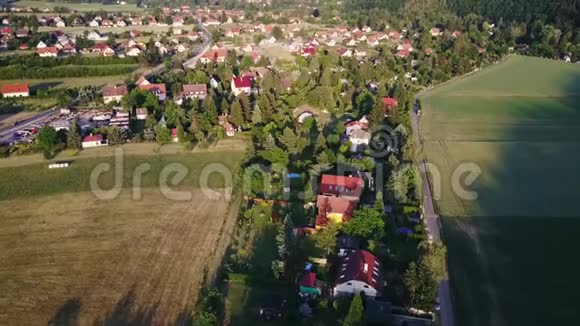 空中勘测丘陵间的乡村山谷飞越红色屋顶的小房子视频的预览图