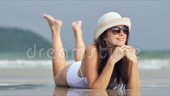 戴墨镜的年轻美女在热带海滩放松和日光浴视频的预览图